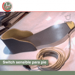 En la imagen se ve una base de madera, con una forma específica para adaptarse a un calzado, y de esta manera funcionar para manejar dispositivos digitales.